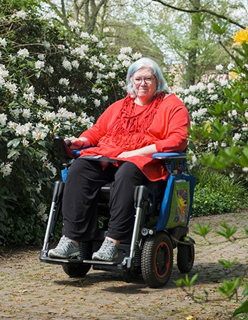 Karin in haar elektrische rolstoel met een Lewis zitorthese in het Gouverneurspark in Assen.